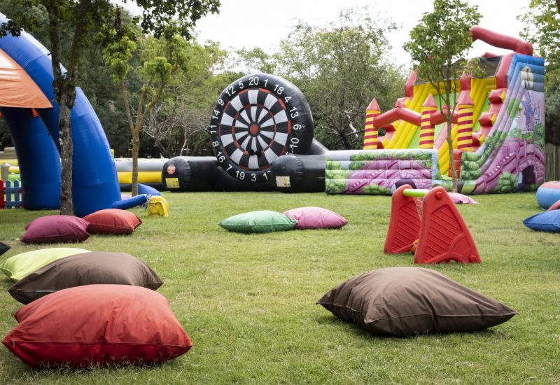A relaxing space playground with large pillows and inflatables over grassy area. A fun playground for kids and their parents.